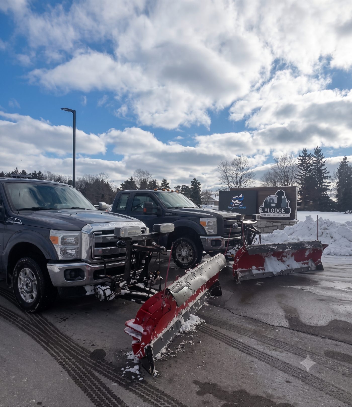 Commercial plow truck fleet staged at a property lot